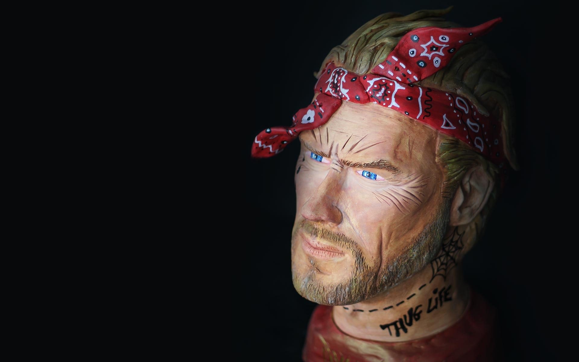 Buste en couleur au bandana rouge portant l’inscription THUG LIFE